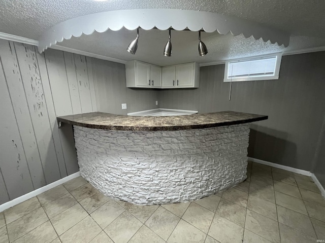 bar featuring wood walls, bar, a textured ceiling, and light tile patterned flooring