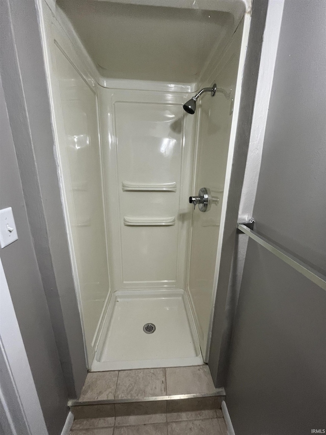 full bath with a stall shower and tile patterned flooring