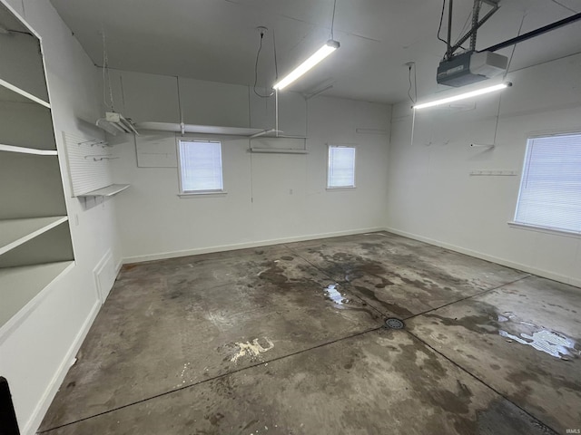 garage featuring a garage door opener and baseboards