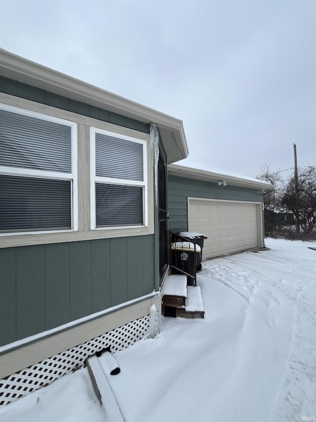 snow covered property featuring a garage