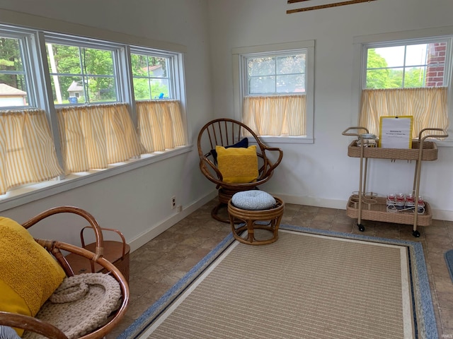 sitting room featuring a healthy amount of sunlight and baseboards