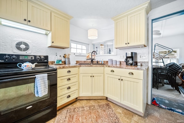 kitchen featuring visible vents, backsplash, cream cabinets, a sink, and black / electric stove