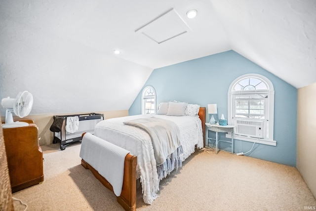 bedroom featuring lofted ceiling, cooling unit, attic access, and light colored carpet