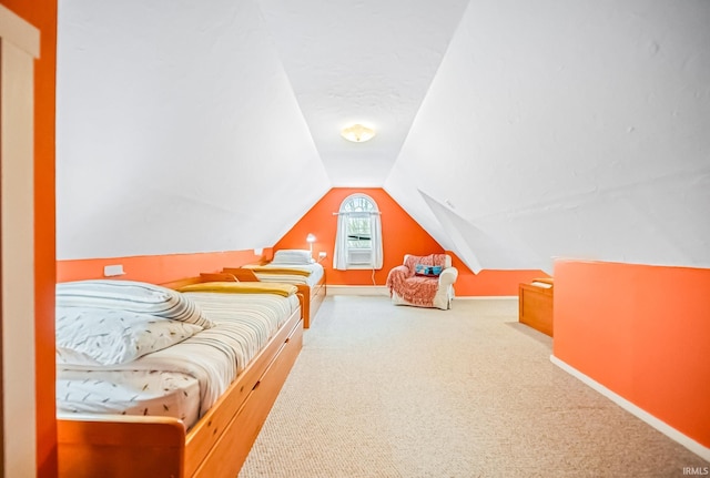 carpeted bedroom with vaulted ceiling and baseboards