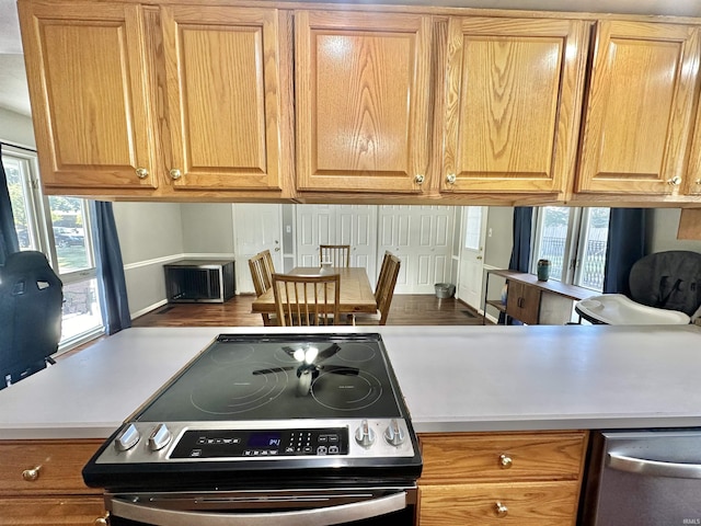 kitchen featuring stainless steel appliances, brown cabinets, and light countertops