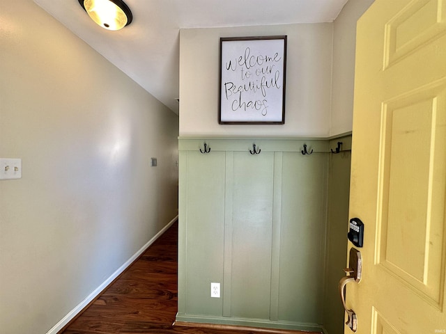 mudroom with dark wood finished floors and baseboards