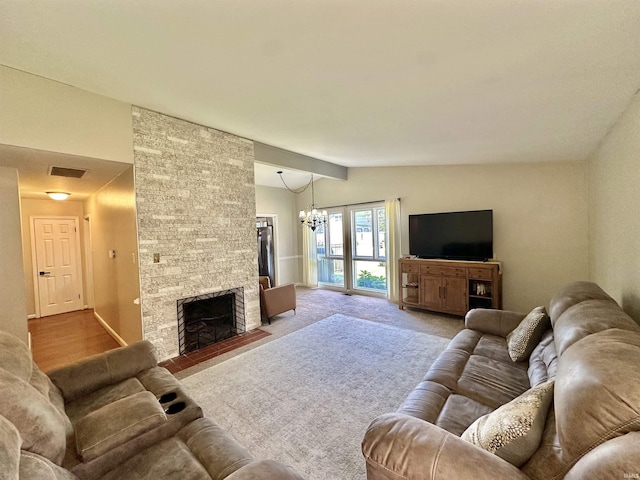 living area featuring a notable chandelier, light carpet, a fireplace, visible vents, and vaulted ceiling