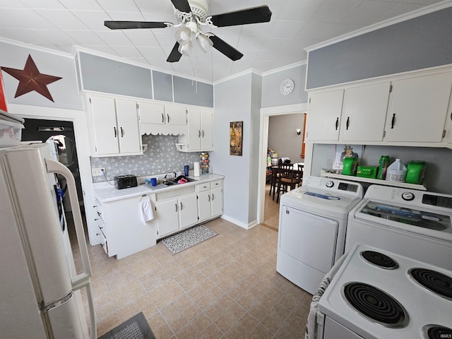 kitchen featuring freestanding refrigerator, white cabinetry, light countertops, and independent washer and dryer