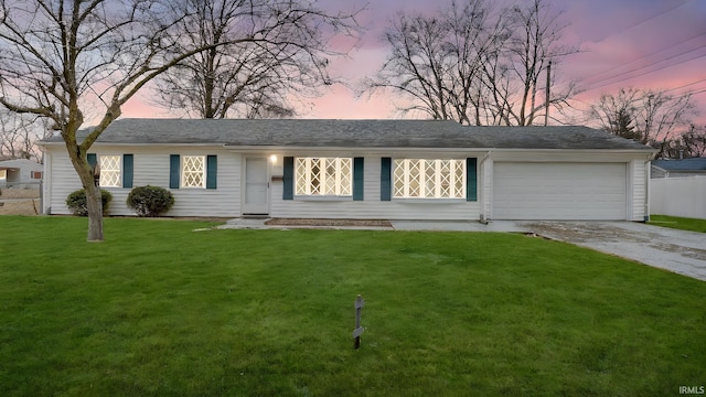 ranch-style house featuring a garage, a front yard, and driveway