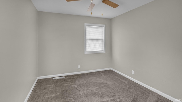 unfurnished room with carpet floors, visible vents, baseboards, and a ceiling fan