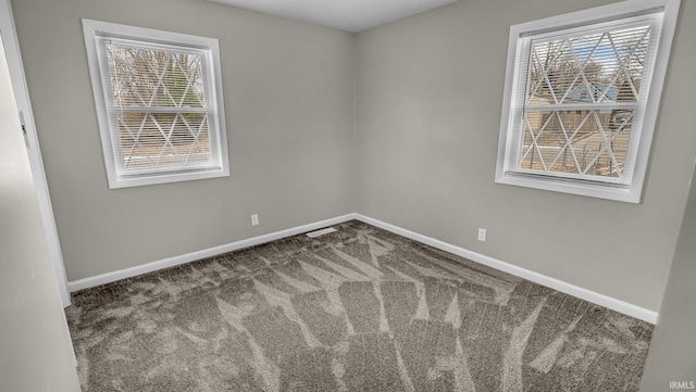 carpeted empty room featuring visible vents, plenty of natural light, and baseboards