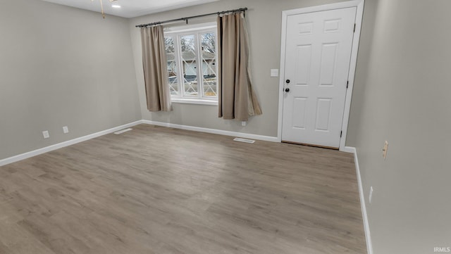 interior space with baseboards, visible vents, and light wood-style floors