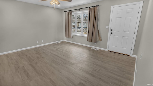 empty room featuring baseboards, visible vents, light wood-style flooring, and a ceiling fan