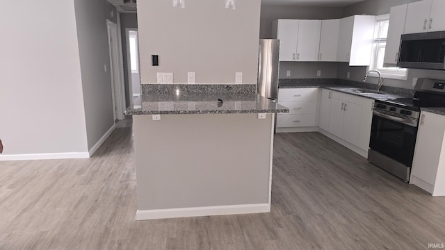 kitchen with stainless steel appliances, white cabinetry, and a sink