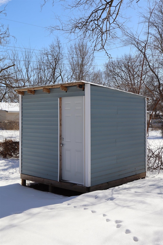 snow covered structure featuring an outdoor structure