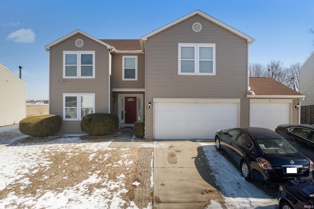 traditional home with an attached garage, a shingled roof, and concrete driveway