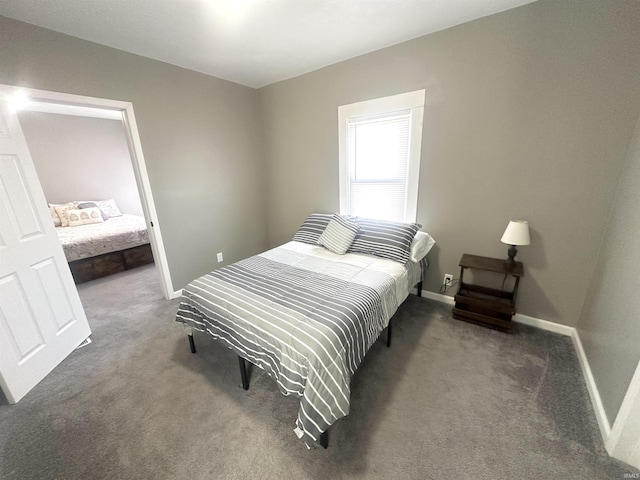 bedroom featuring dark carpet and baseboards