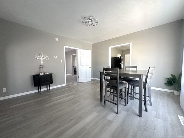 dining space with dark wood finished floors and baseboards