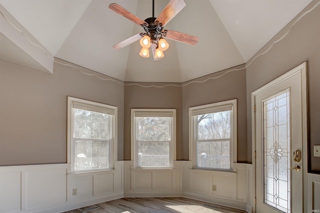 interior space with visible vents, wainscoting, ceiling fan, wood finished floors, and a decorative wall