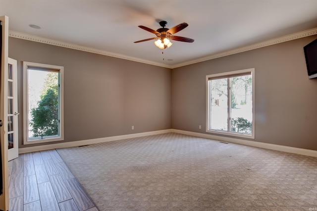 spare room featuring baseboards, crown molding, a ceiling fan, and a healthy amount of sunlight