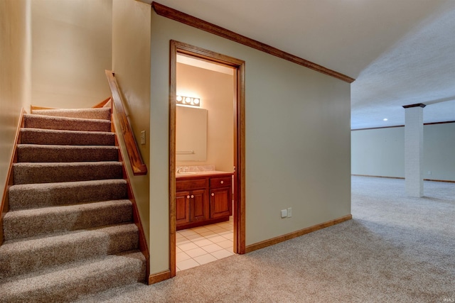 staircase with carpet, baseboards, crown molding, and tile patterned floors