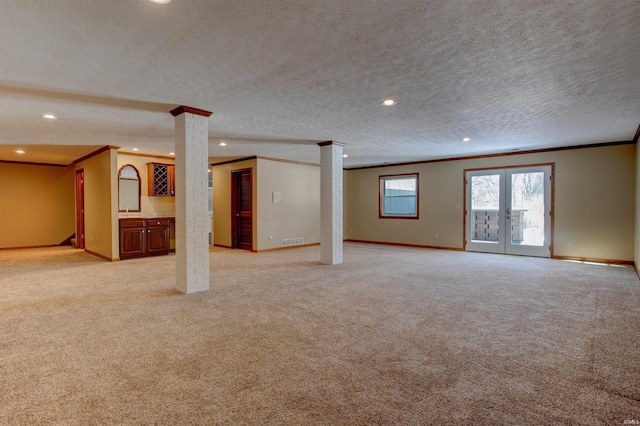 interior space with french doors, light colored carpet, a textured ceiling, and baseboards