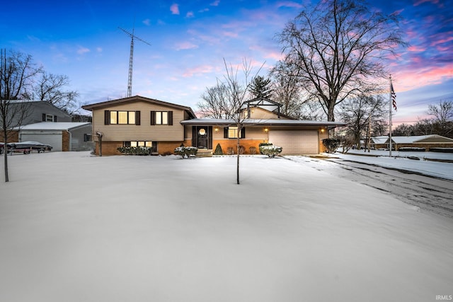 tri-level home with a garage and brick siding