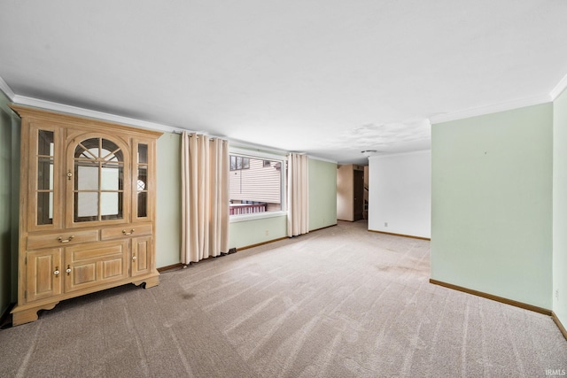 interior space with baseboards, light colored carpet, and crown molding