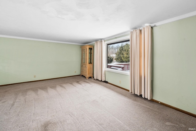 empty room featuring ornamental molding, carpet flooring, and baseboards