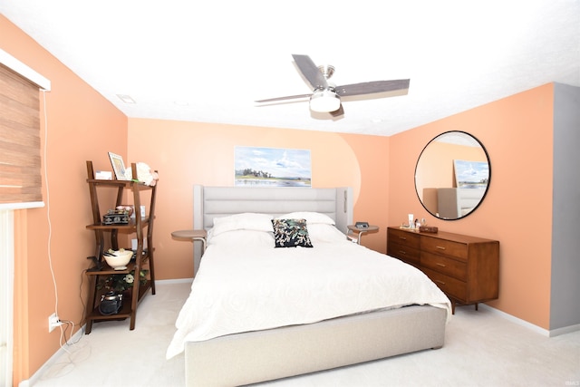 bedroom featuring light carpet, ceiling fan, and baseboards