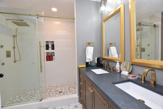 full bath featuring double vanity, a stall shower, and a sink