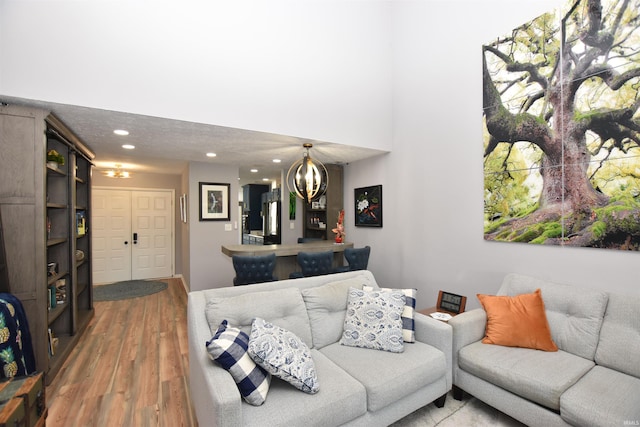 living area with a notable chandelier, wood finished floors, and recessed lighting