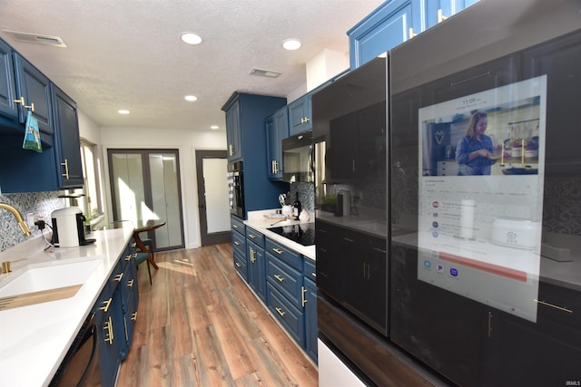 kitchen featuring blue cabinets, light countertops, and a sink