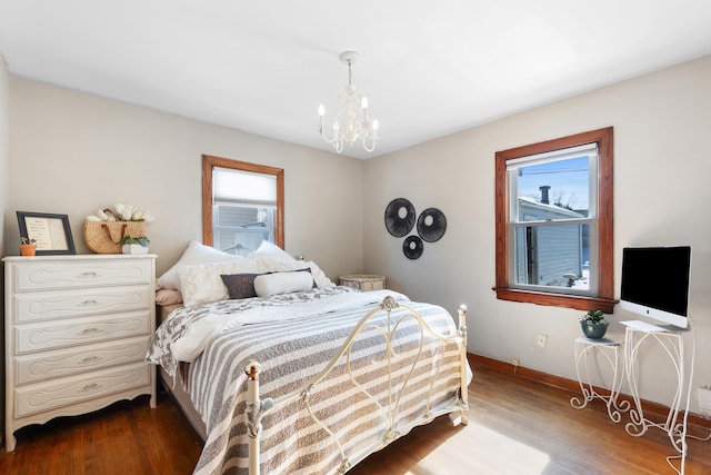 bedroom with a chandelier, baseboards, and wood finished floors