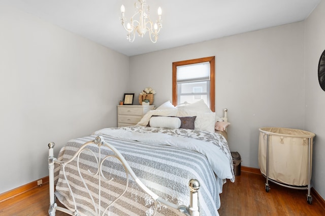 bedroom featuring dark wood-type flooring, an inviting chandelier, and baseboards