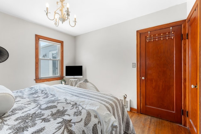 bedroom with light wood-style floors, baseboards, and a notable chandelier