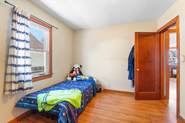 bedroom with light wood finished floors and baseboards