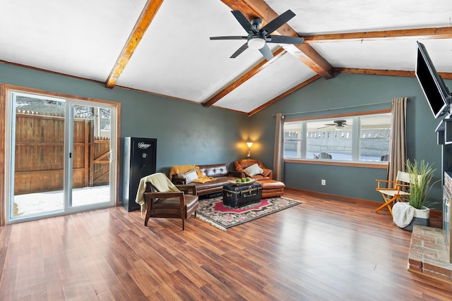 living area with vaulted ceiling with beams, a ceiling fan, and wood finished floors