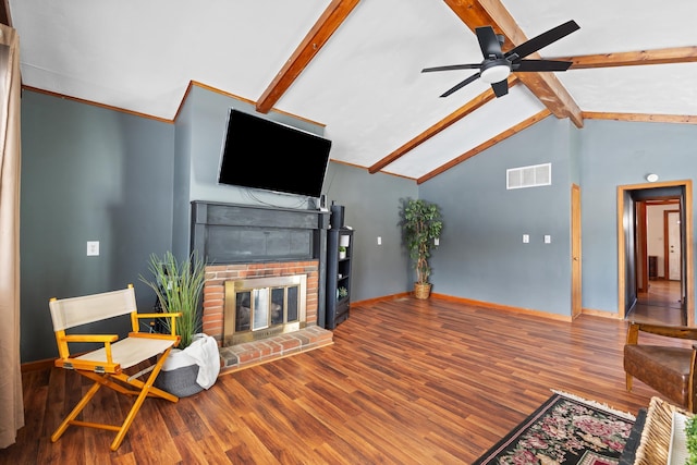 living area with visible vents, lofted ceiling with beams, a brick fireplace, wood finished floors, and baseboards