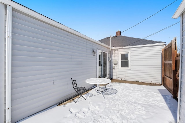 snow covered patio featuring fence