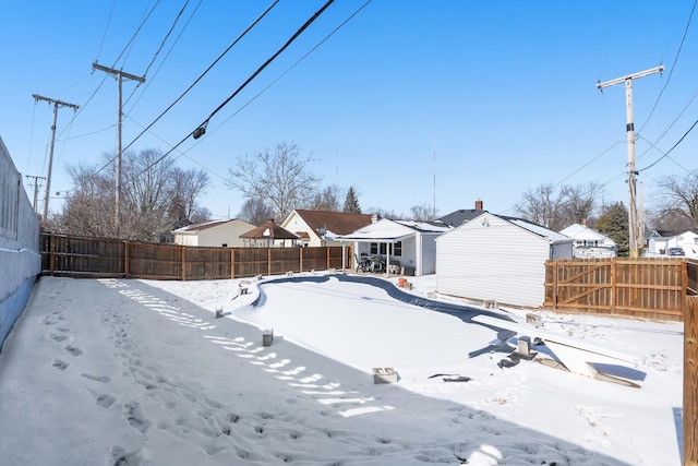 snowy yard with fence and a residential view