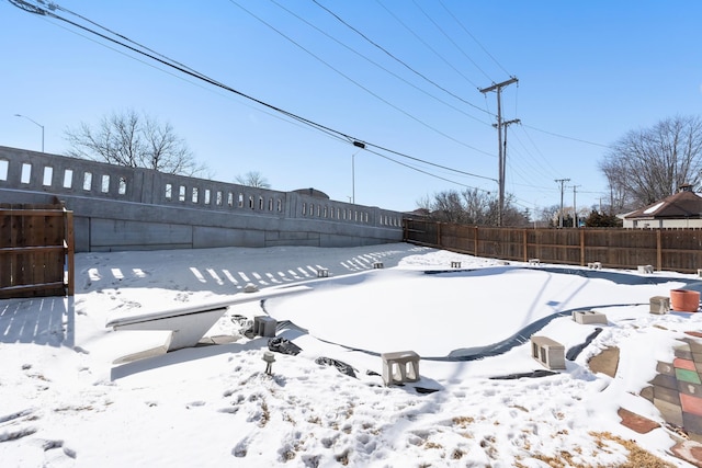 snowy yard with a fenced backyard