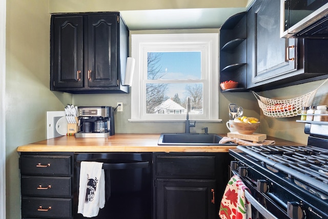 kitchen featuring dark cabinetry, a sink, and black appliances