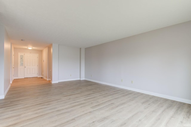 empty room featuring baseboards and light wood-style floors