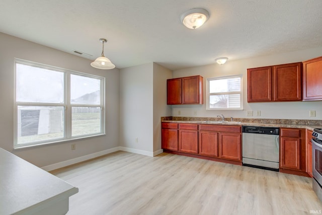 kitchen featuring appliances with stainless steel finishes, decorative light fixtures, light wood-style flooring, and visible vents