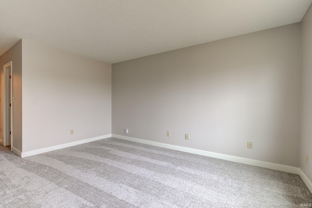 empty room with baseboards and light colored carpet