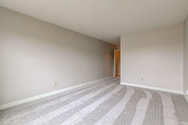 carpeted spare room with baseboards