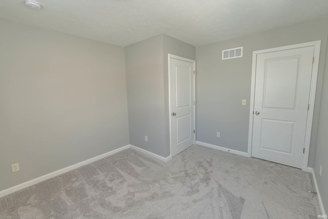 interior space with visible vents, light carpet, and baseboards