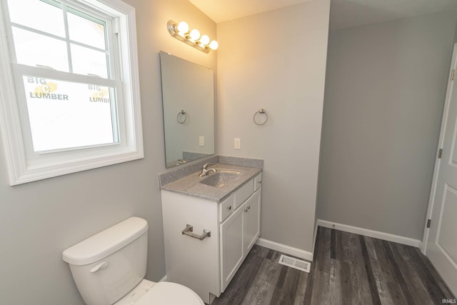 bathroom featuring wood finished floors, vanity, visible vents, and baseboards