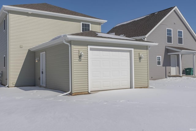 exterior space with roof with shingles and an attached garage